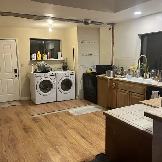 The kitchen mid-renovation, washer and dryer in the middle of the room